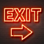 Exit neon sign on brick wall background